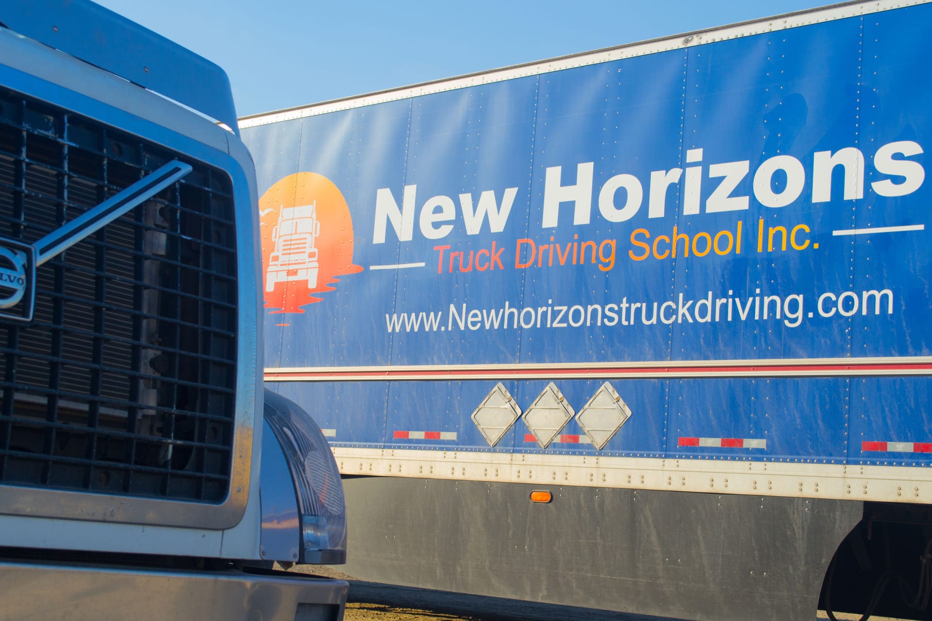New Horizons Volvo tractor with branded trailer at the training yard
